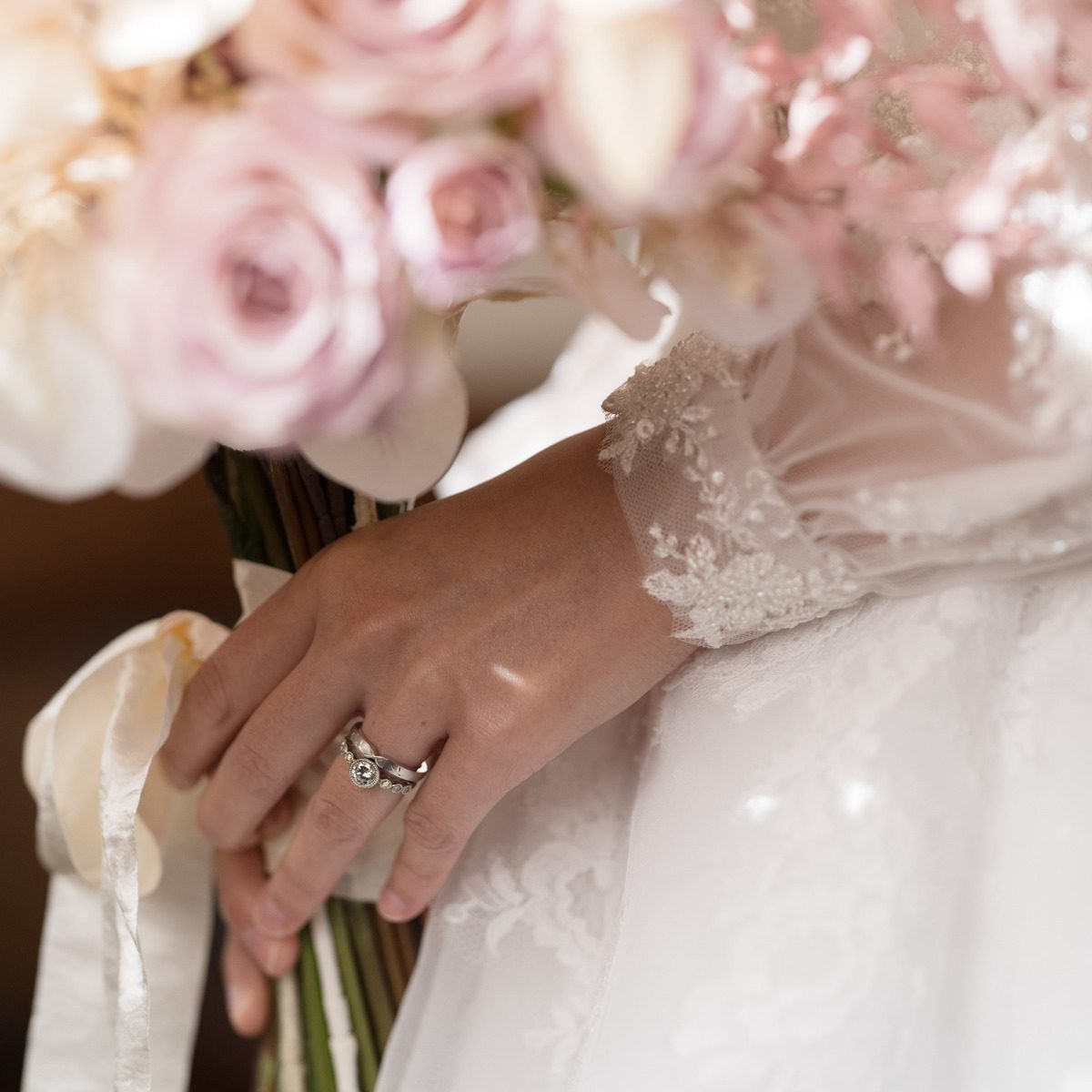 指輪をつけた新婦の手元とブーケのクローズアップ