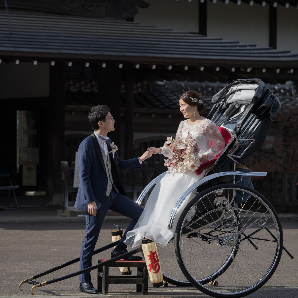人力車に乗り込む新婦の手を取る新郎