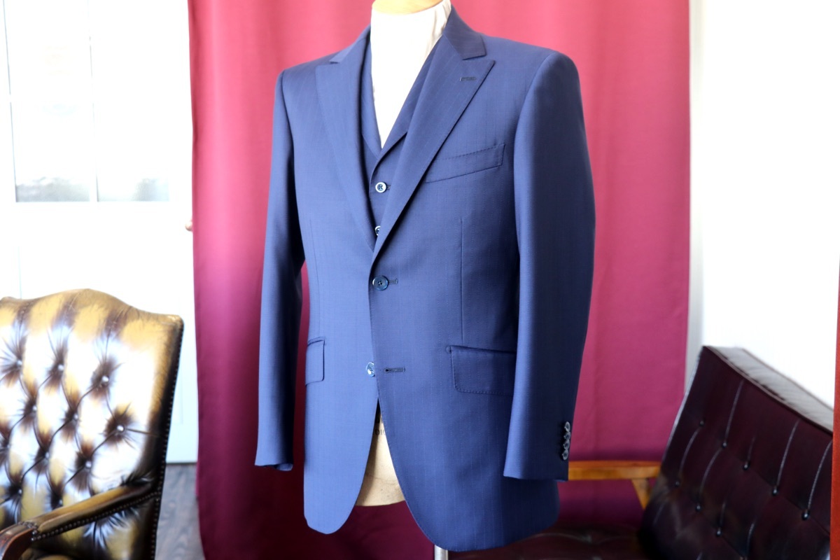 襟付きベストとセミピークのジャケットが特徴的なネイビーブルーの 